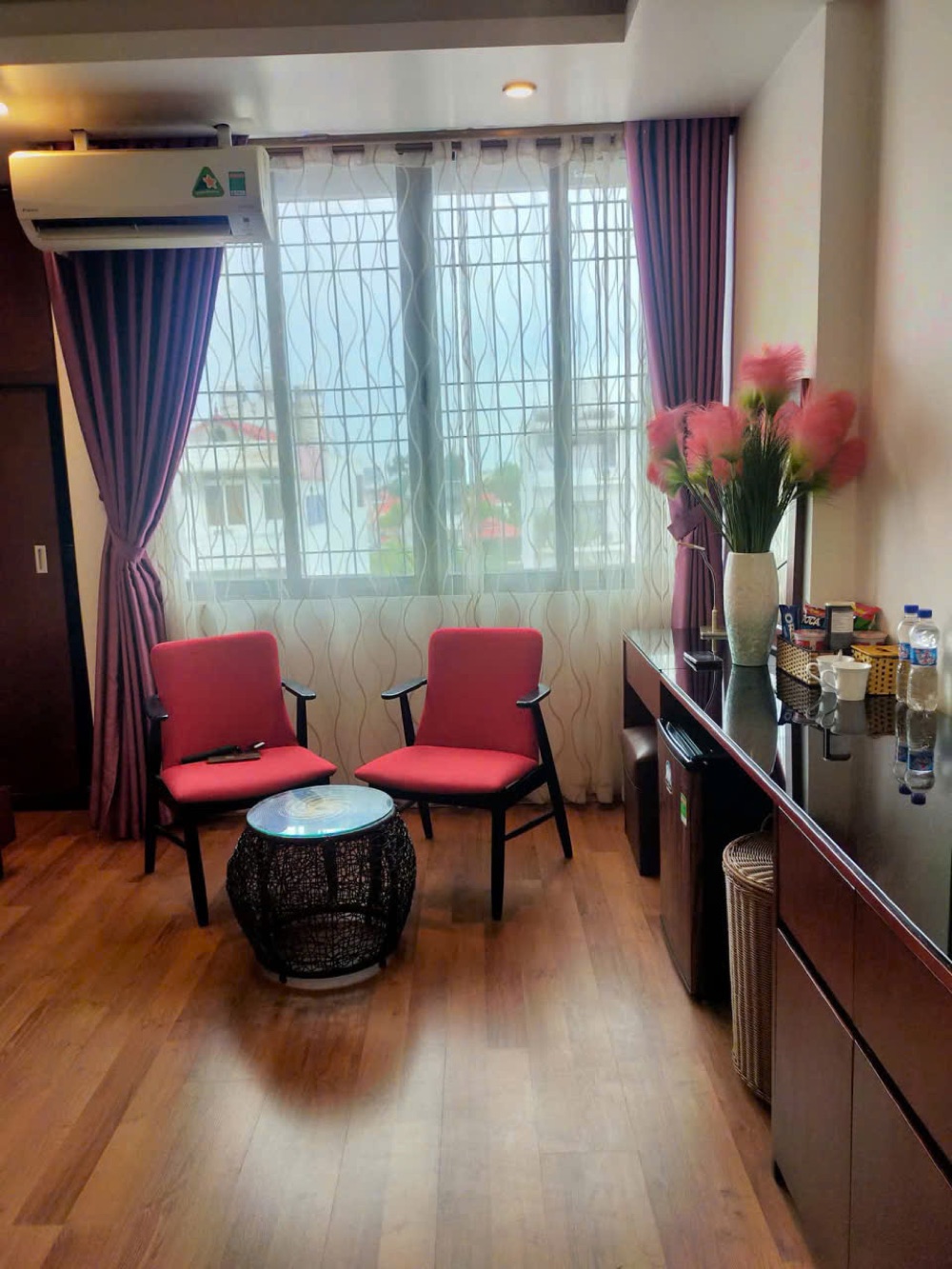 Reading corner in a Camellia Hotel room with red armchairs and fresh flowers